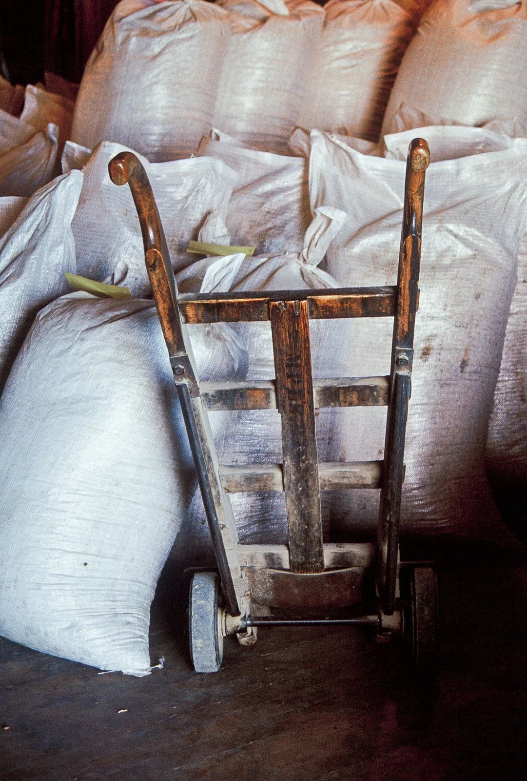 Bags of beans sit in a pile next to a dolly at a bean elevator in Powell, Wyoming.