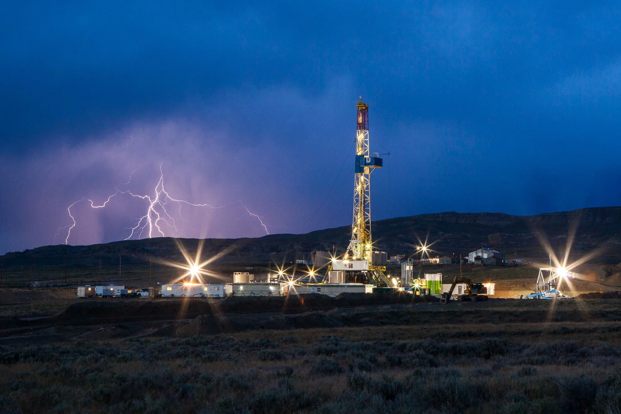 Thunderstorm and lightning strikes near an oil and gas drilling rig in central Wyoming.