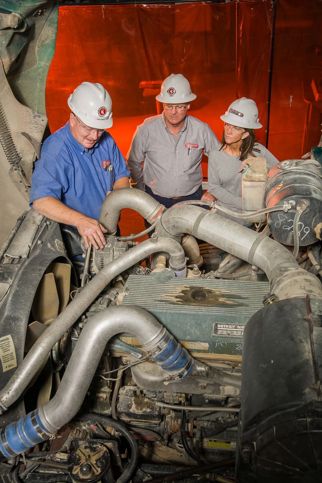 Education and training photography for marketing and editorial use, including an instructor with students in a diesel mechanic shop.