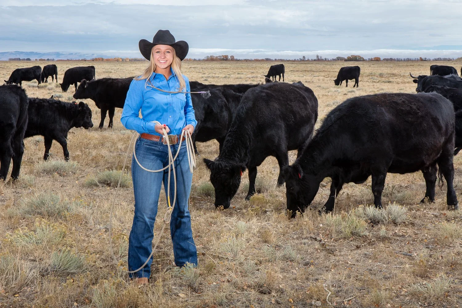 Senior portraits in Laramie, Wyoming. Cowgirl with cattle.