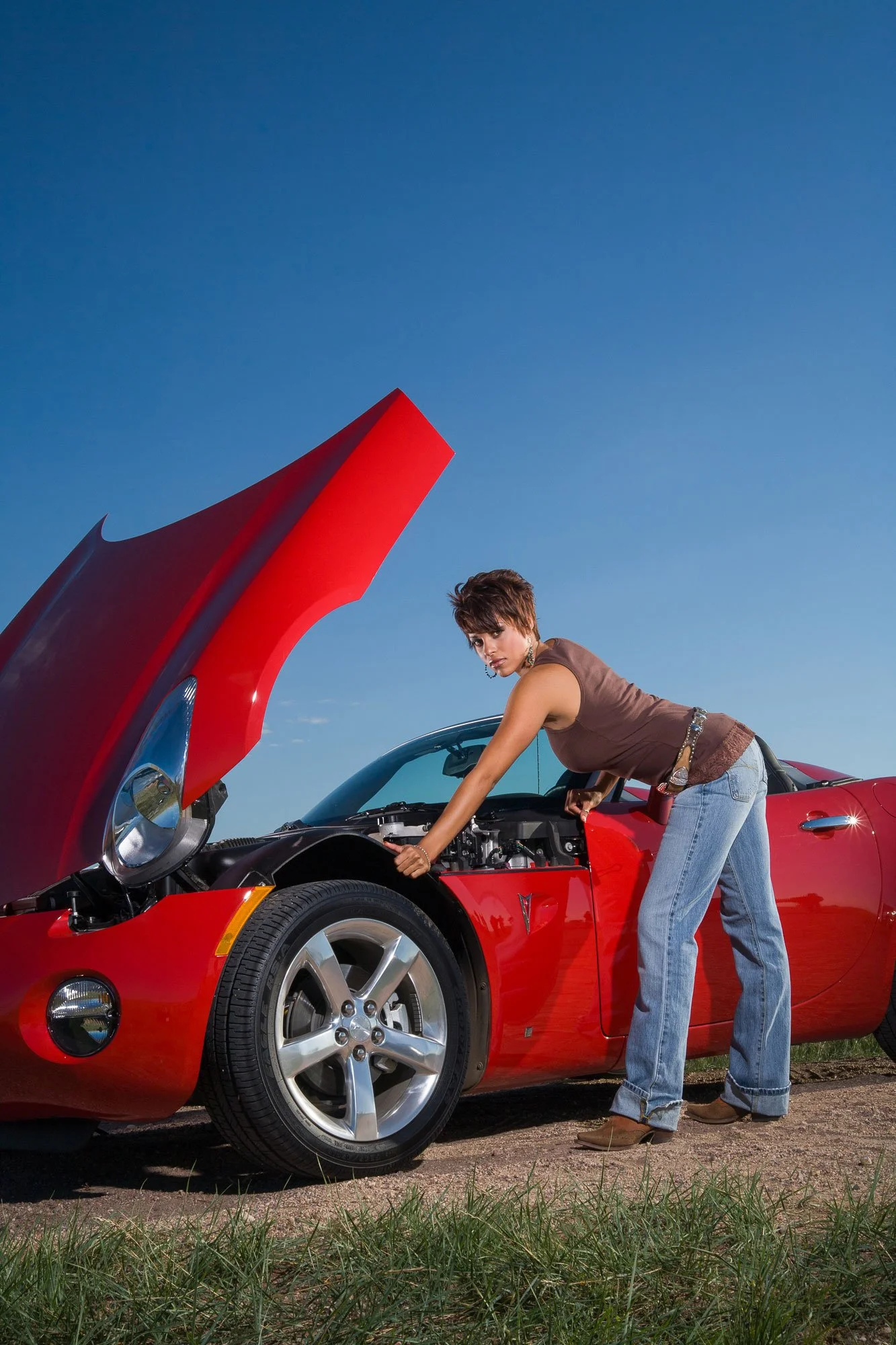 Portrait with product photography for marketing for a western store in Cheyenne, Wyoming, including a woman with a bright red sports car.