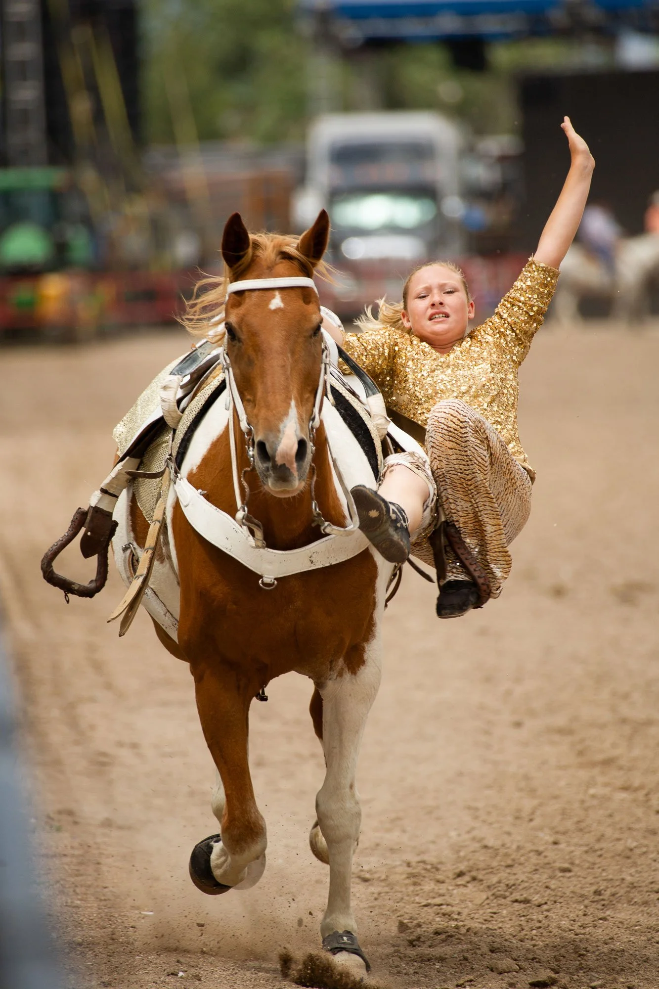 A trick rider hangs off her horse and shows off her trick riding at the rodeo at Cheyenne Frontier Days.
