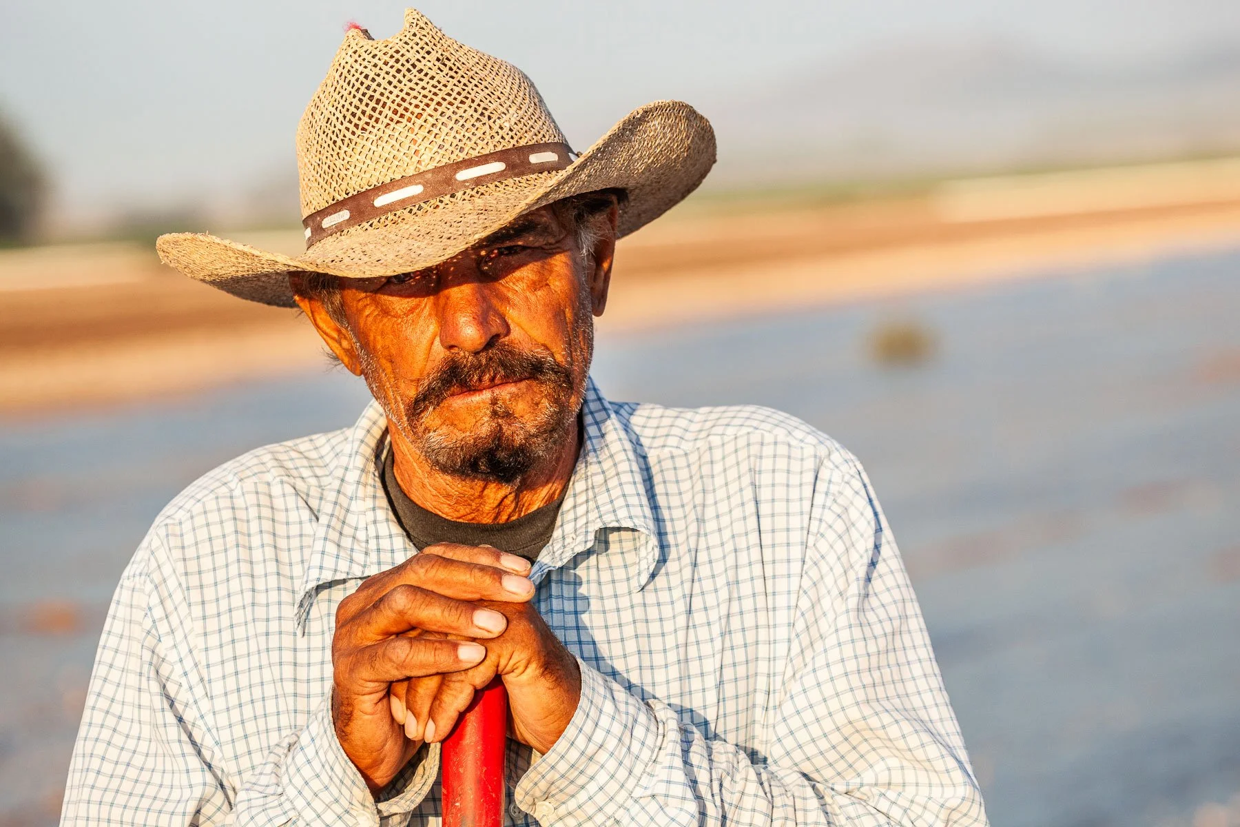 Farmhand with cowboy hat irrigating crops at the CLM Farm near Dell City, Texas.