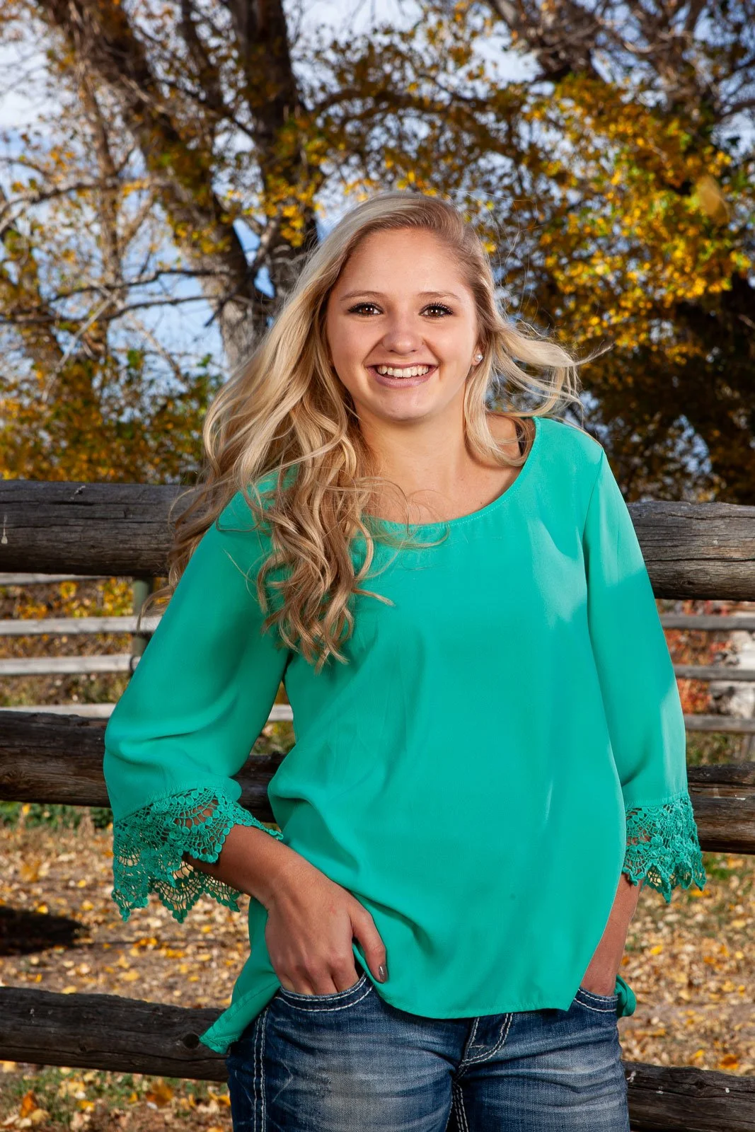 Senior portraits in Cheyenne, Wyoming with fall colors and wood fence.