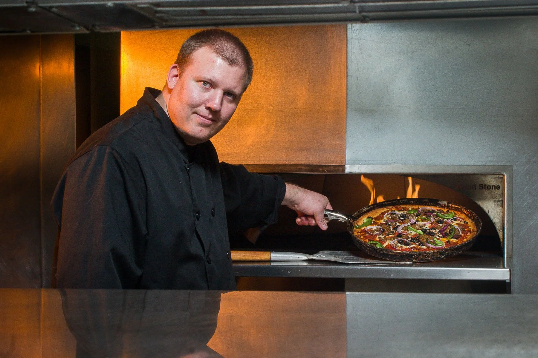 Restaurant portrait of Chef cooking a pizza in Cheyenne, Wyoming.