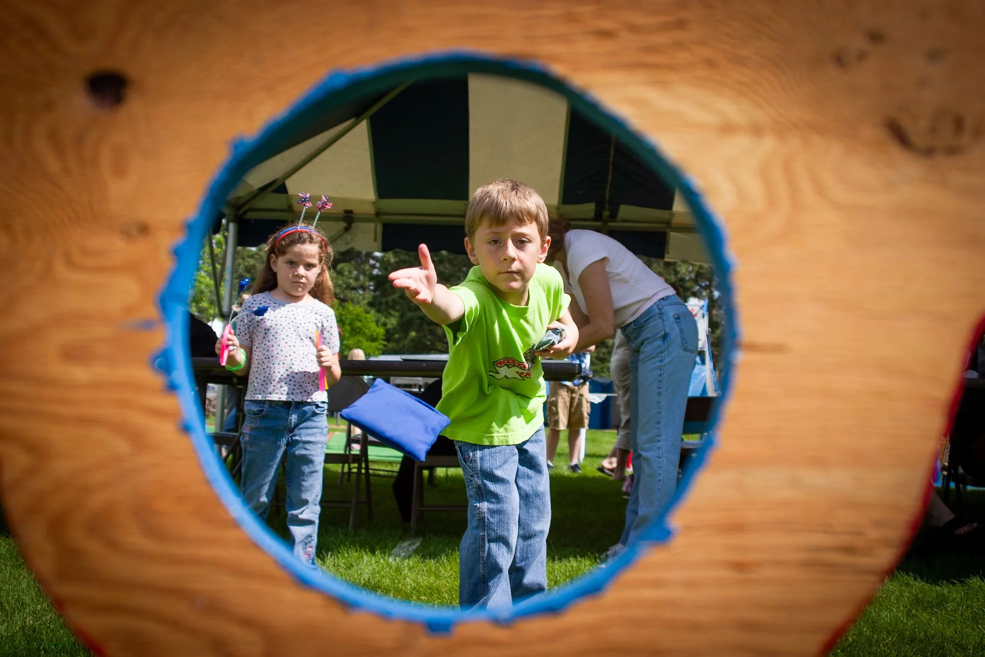 Boy tossing a bean bag into a hole at Superday in Cheyenne, Wyoming, on June 26, 2004. Image created for Visit Cheyenne for marketing.