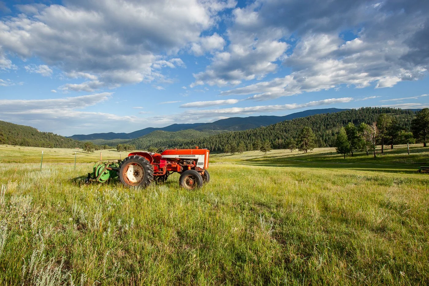 Tractor and hay rake in mountain hay meadow at the Corral Creek Ranch near Evergreen, Colorado.