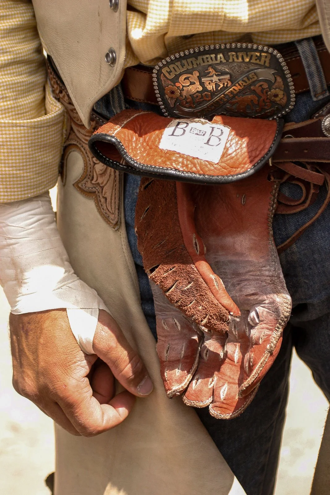 A bull rider's hand, glove, and buckle at the Cheyenne Frontier Days Rodeo in Cheyenne, Wyoming.