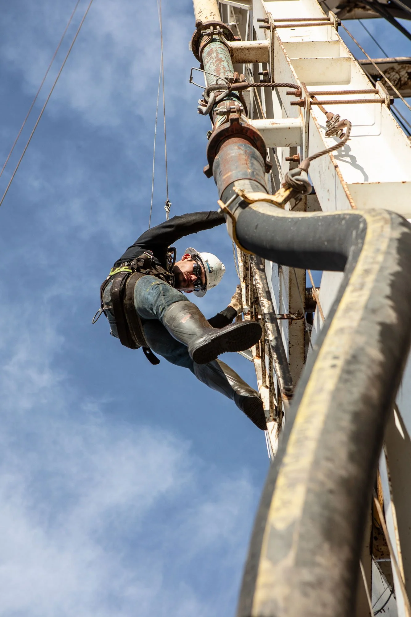 An oil field work comes down the derrick on a oil and gas drilling rig.