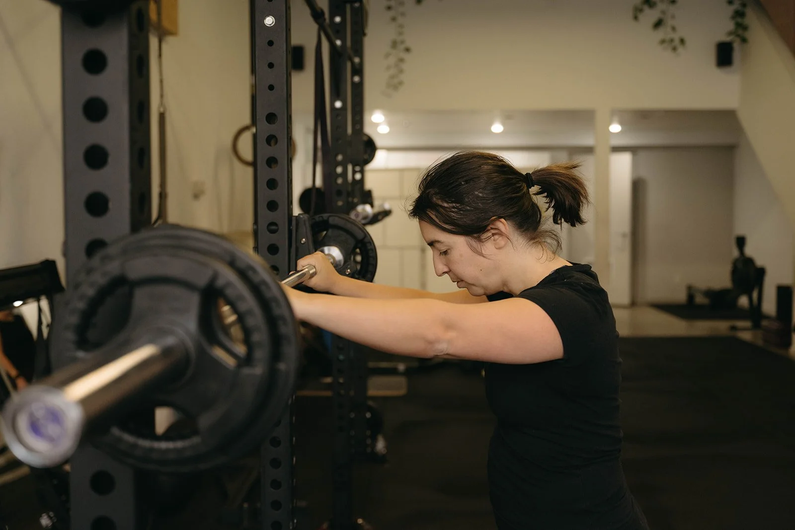 Woman about to lift a barbell in a Toronto inclusive gym
