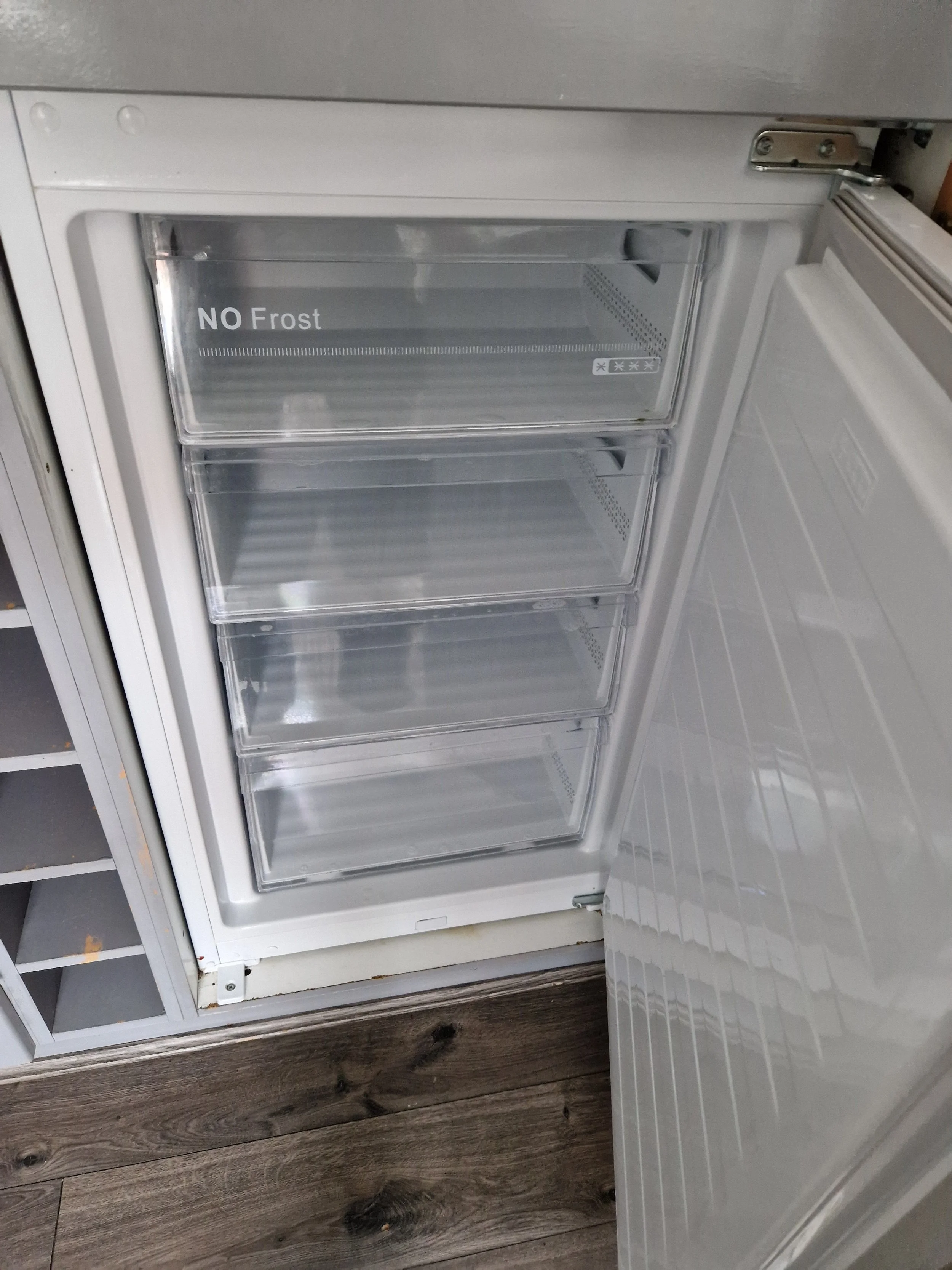 Empty freezer with a sign that reads 'NO Frost' on the door.