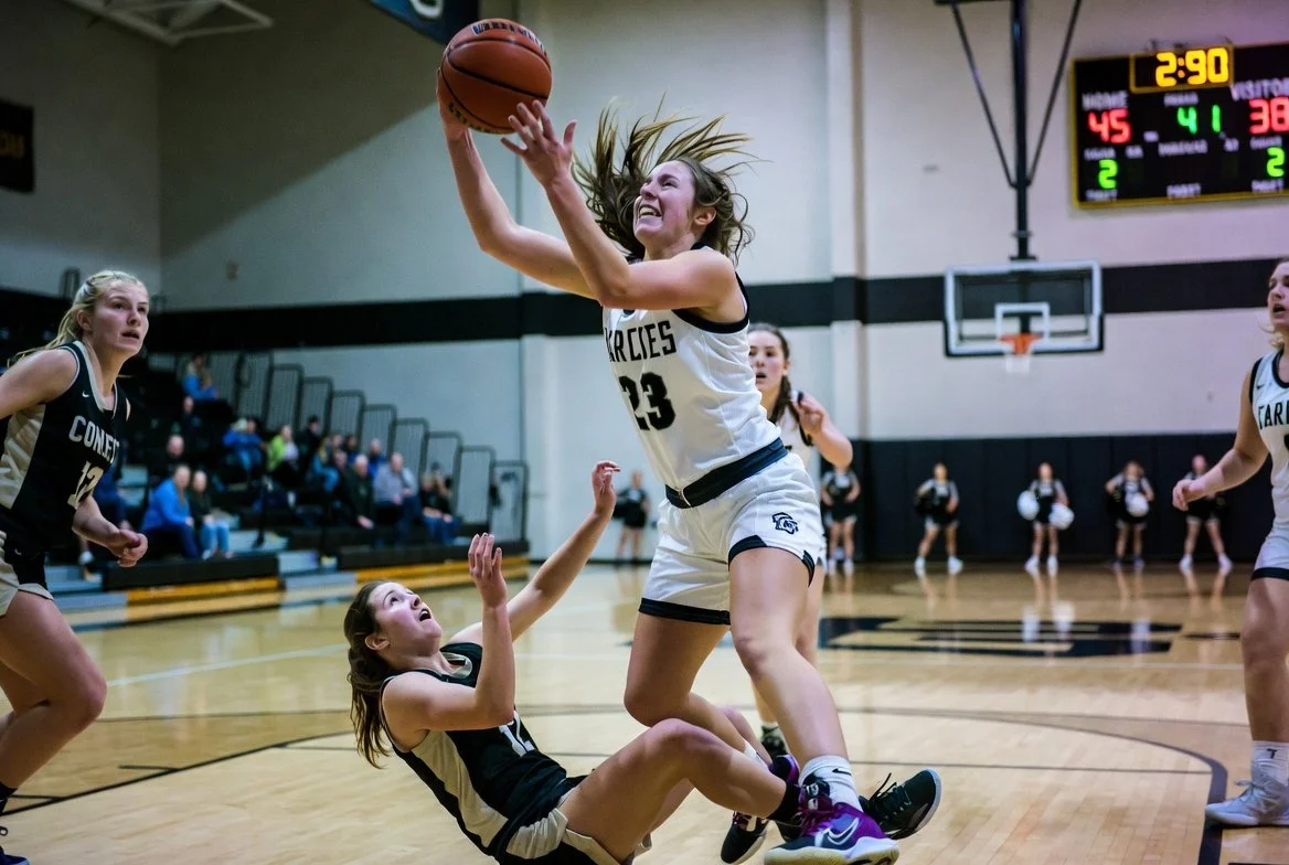 High school girls basketball players collide during a game, illustrating youth sports injury risk and the need for injury prevention.
