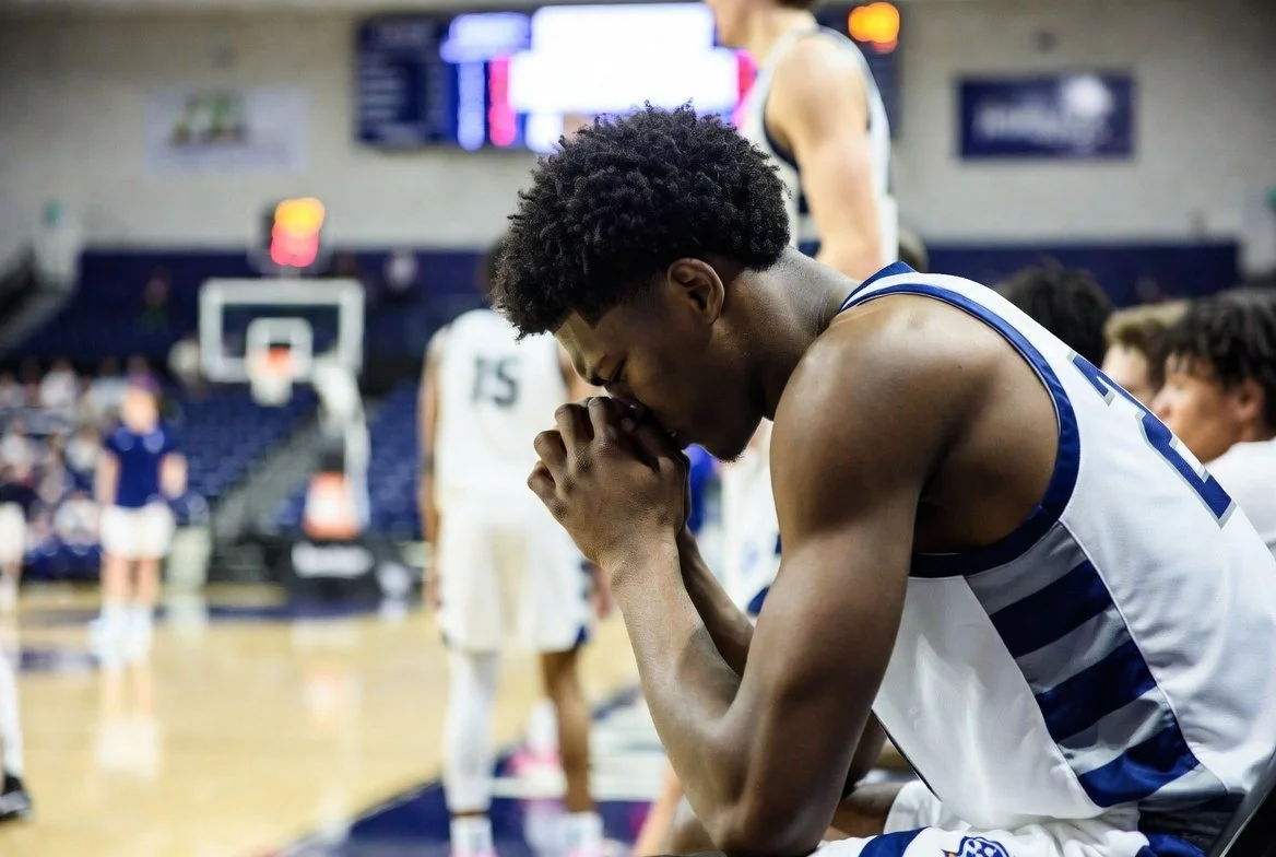 Basketball player sitting on the bench during a game, demonstrating mental toughness, focus, and emotional control