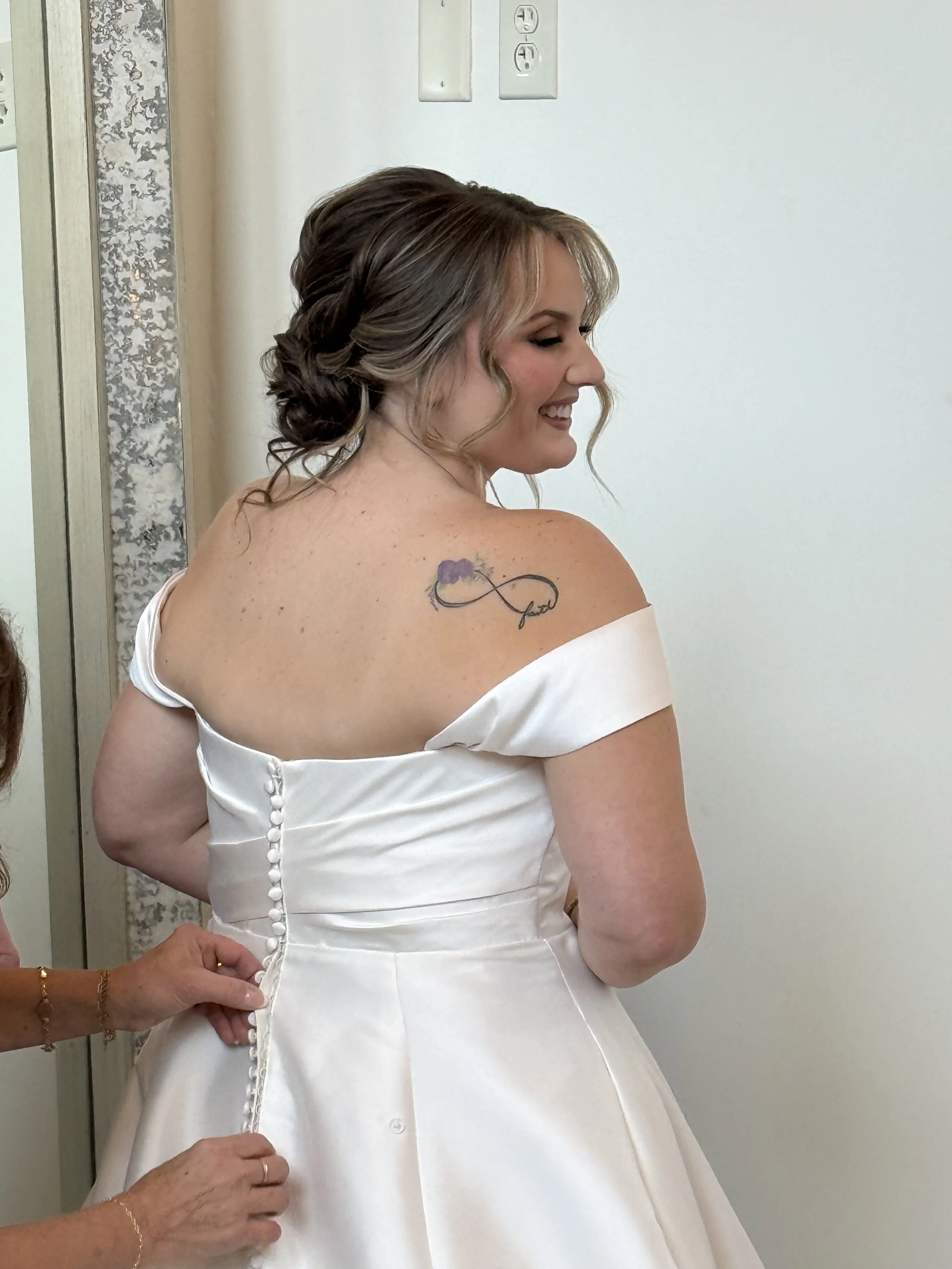 Bride with textured low bun updo getting in her wedding dress