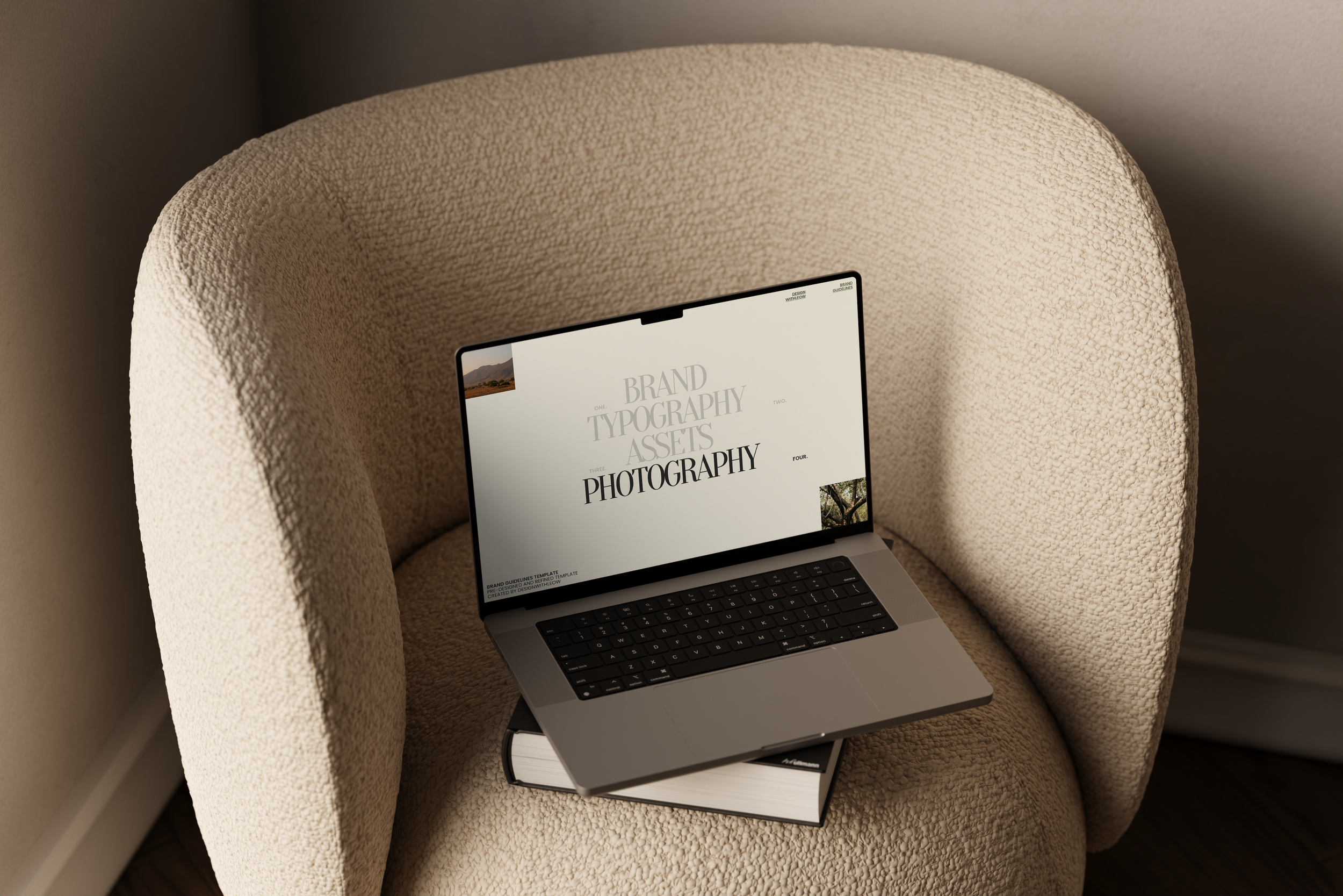 Open laptop on top of a closed book on a beige armchair