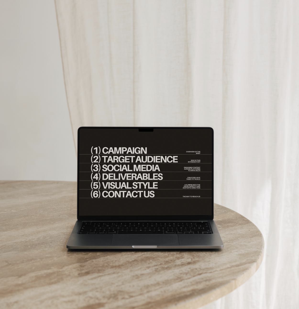 Laptop on wooden table displaying presentation slide with six listed topics in bold white text on a black background.