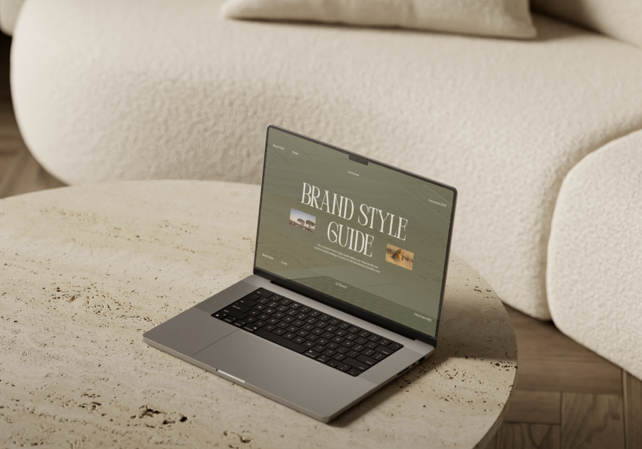 A silver laptop on a round wooden table with a website open displaying 'BRAND STYLE GUIDE' in large text, with part of a beige sofa in the background.