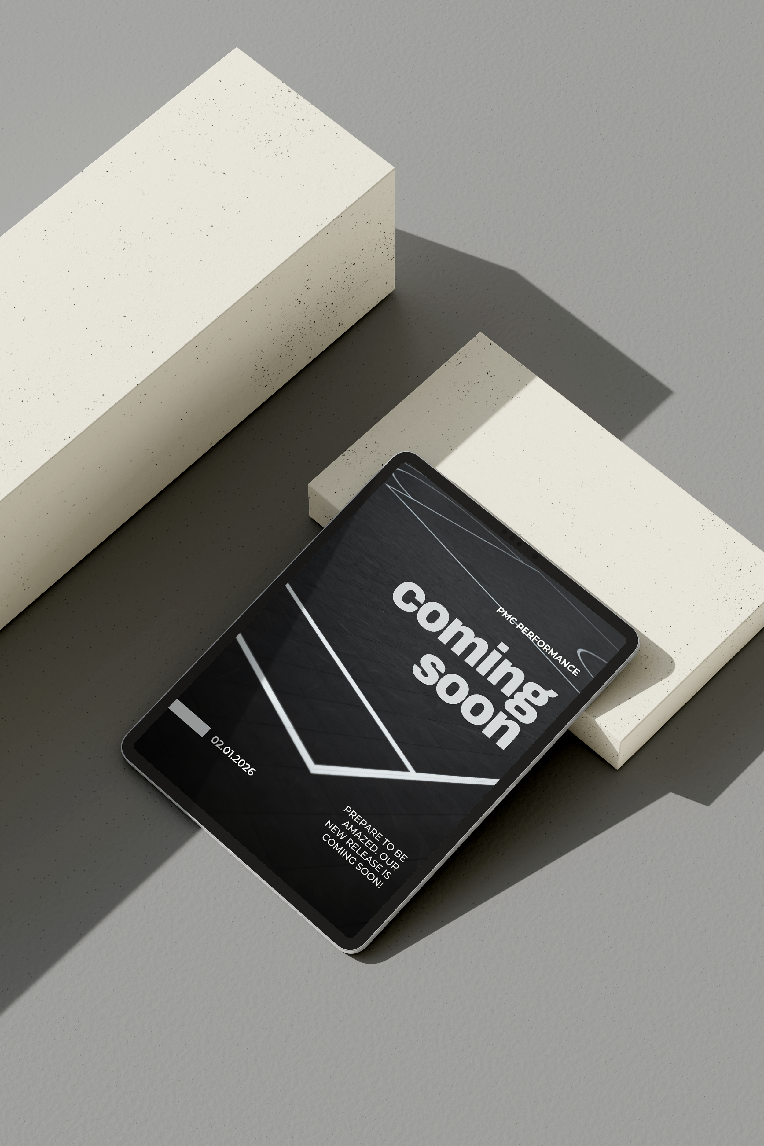 A smartphone displays a black and white announcement screen with the text 'coming soon' and details about an upcoming event, placed on a minimalist surface with white geometric blocks.