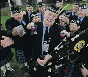 Group of people dressed in Scottish attire, including kilts and holding bagpipes, gathered outdoors for a photo.