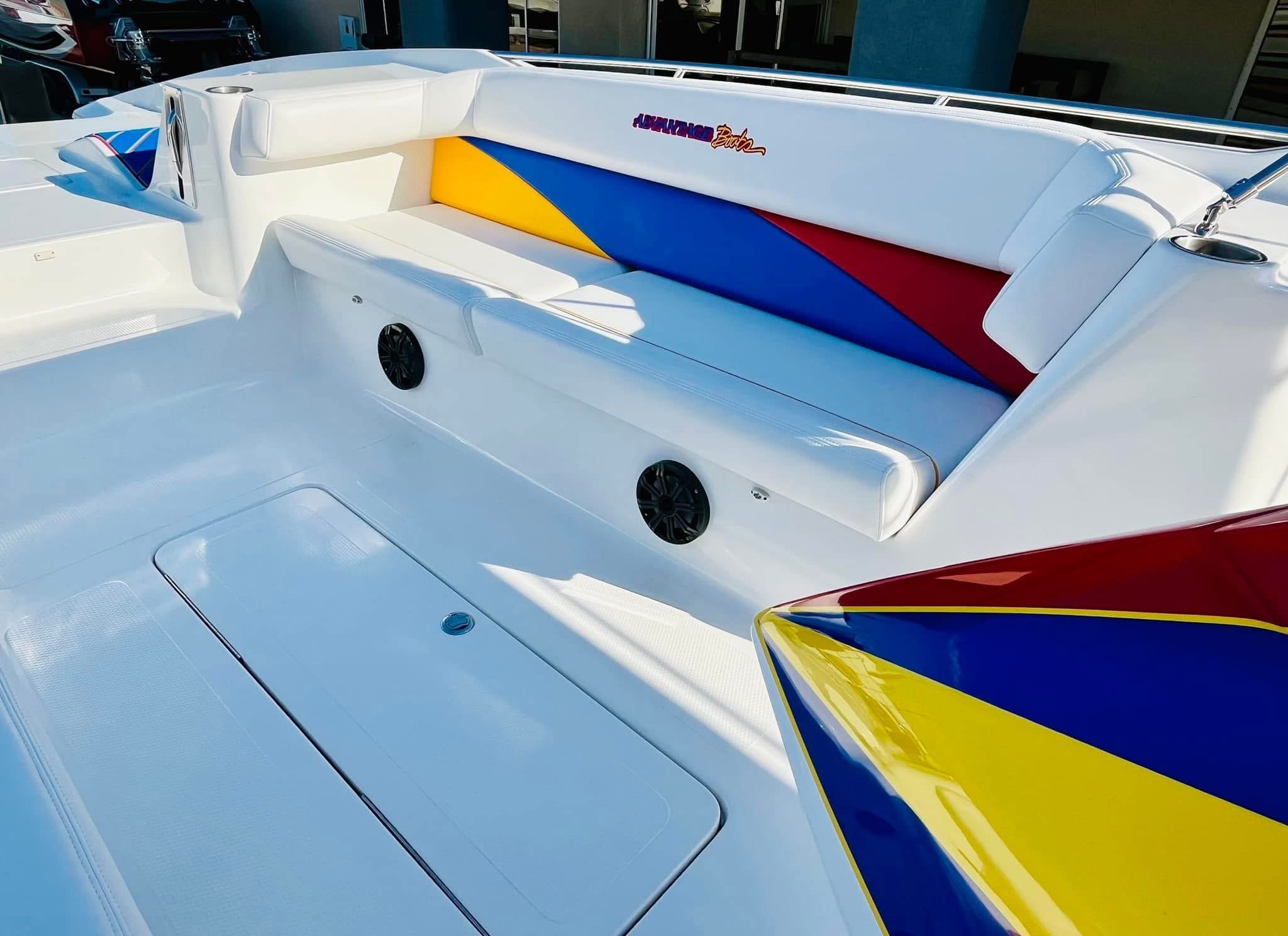 Close-up of a white speedboat with colorful cushions and black speakers