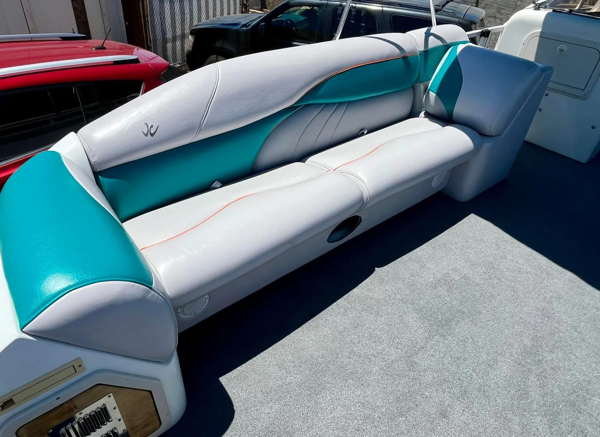 White and teal boat seating with padded cushions on a boat deck.