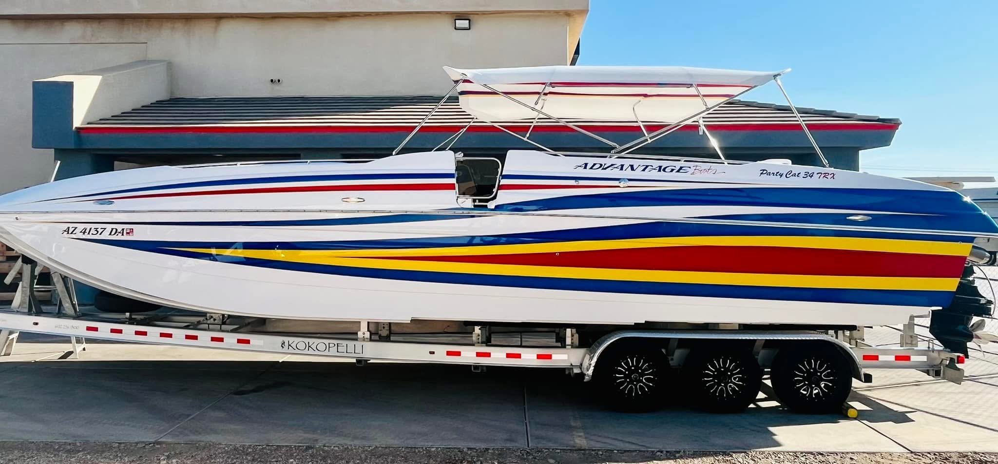 Colorful speedboat on a trailer in front of a building with blue sky.