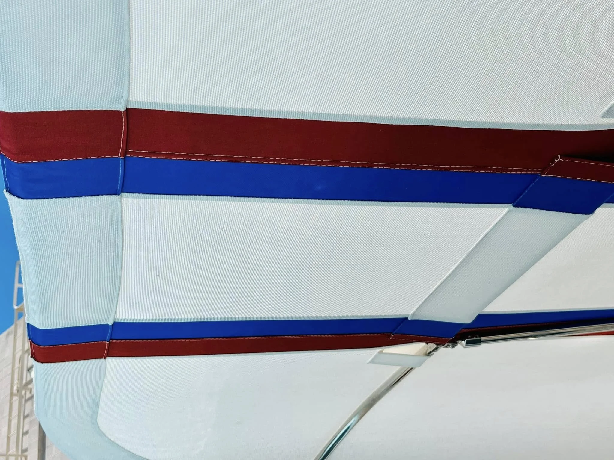 Close-up of a white, red, and blue striped fabric canopy, possibly part of an outdoor structure or tent.