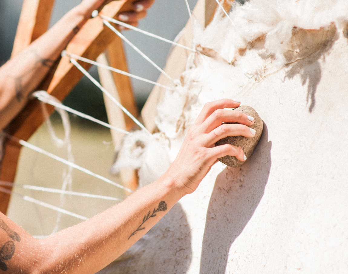 Tanning a sheepskin, buffing with pumice stone
