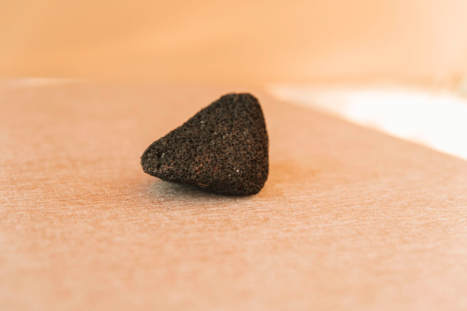 Volcanic pumice stone tool on tanned hide background for hide tanning