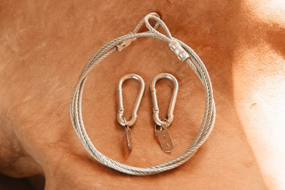 Softening cable kit with carabiners and D-rings laid on tanned hide background