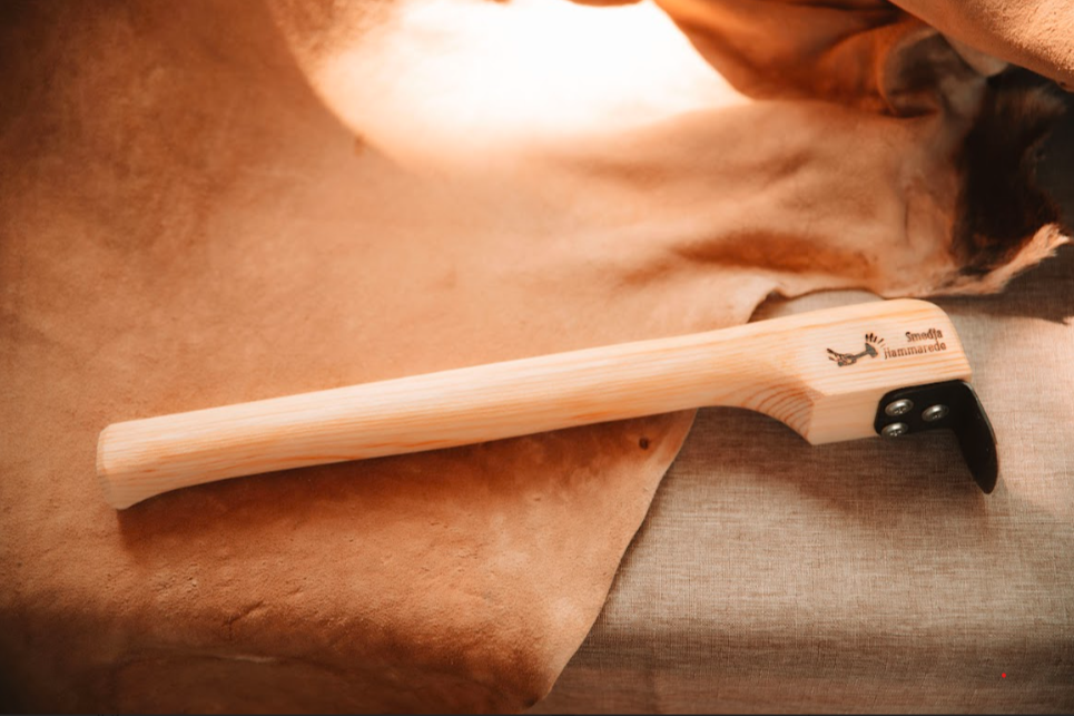 Long-handled dry scraper for hide tanning on tanned hide and linen background