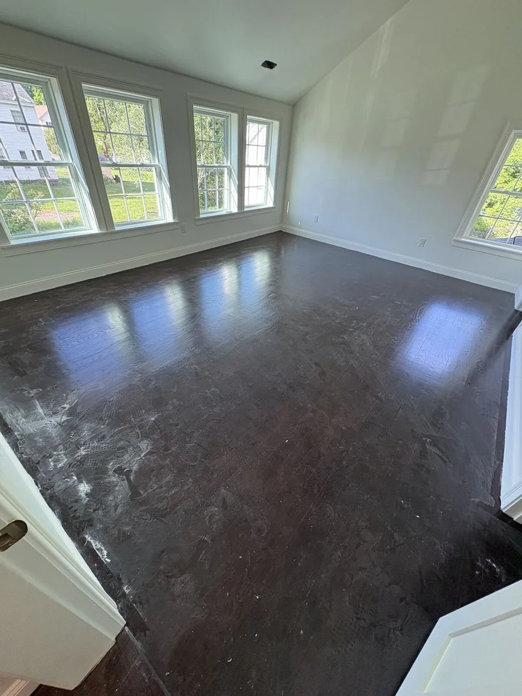 Hardwood floor covered in drywall dust before post-construction cleaning