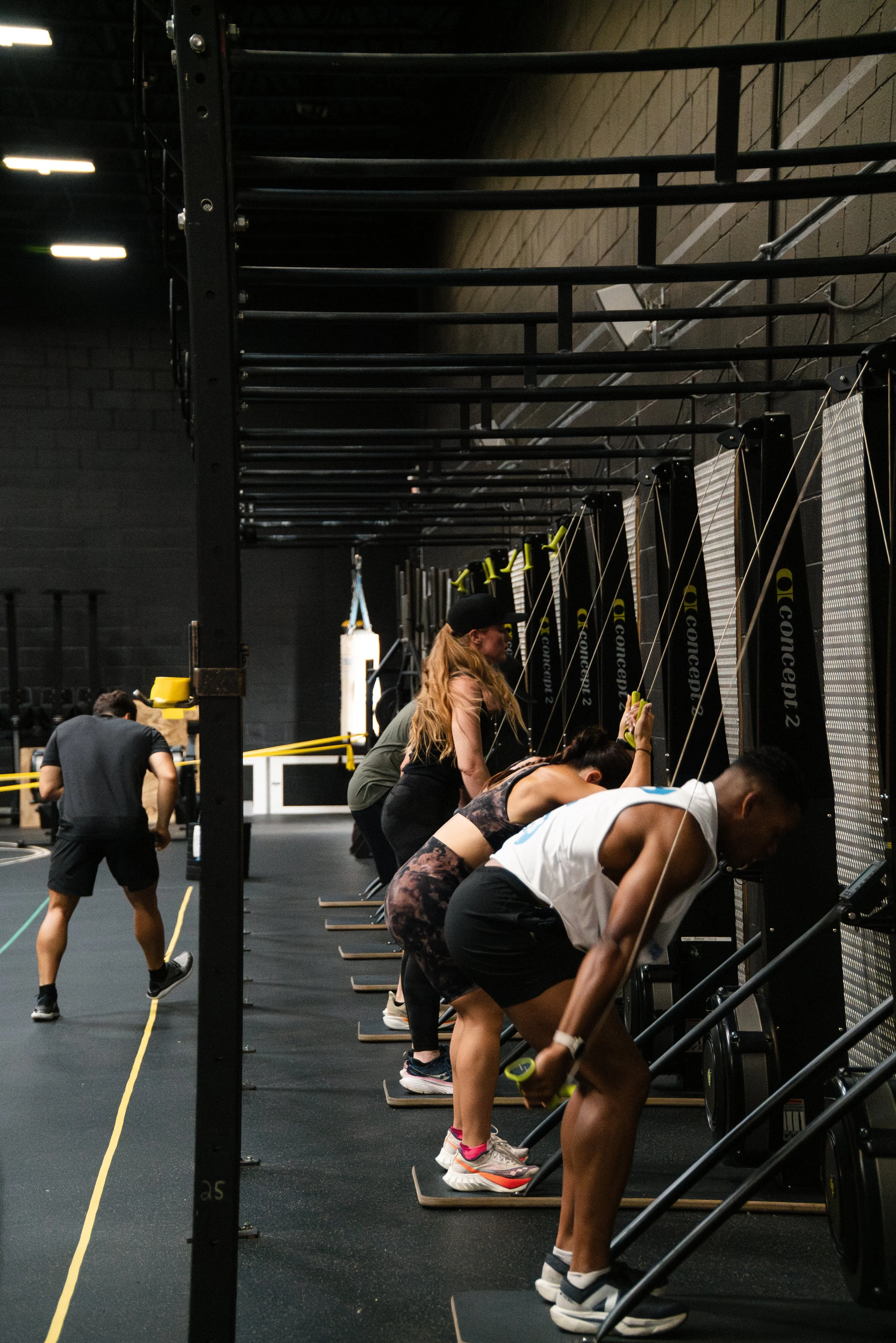 People working out on rowing machines in a gym.