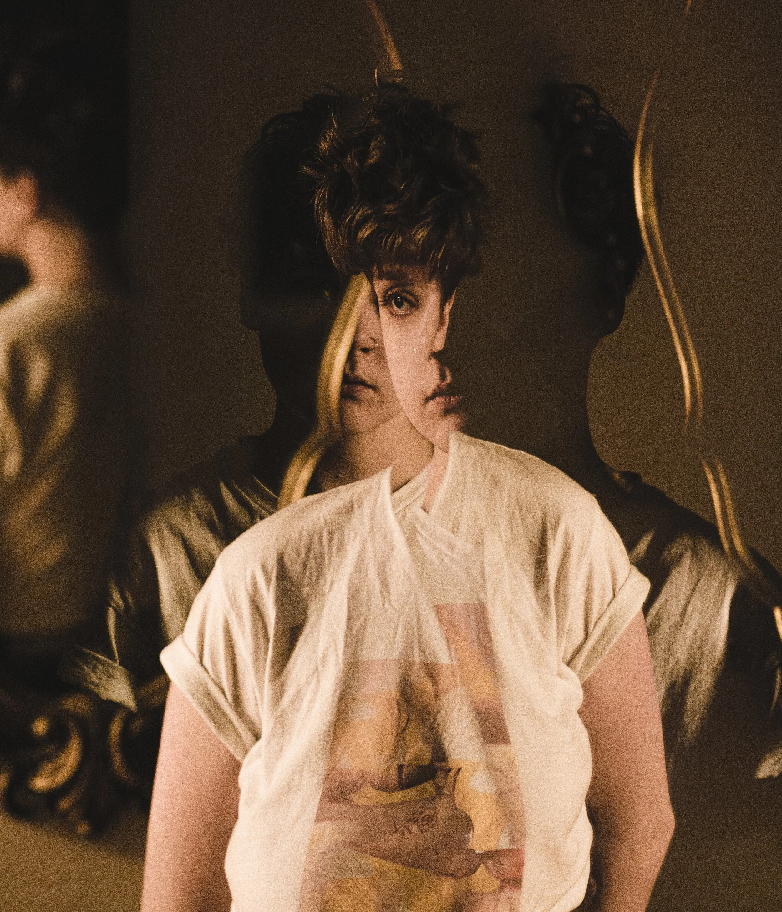 multiple exposure image of woman with short brown hair and white t-shirt. Image colored in sepia tone 