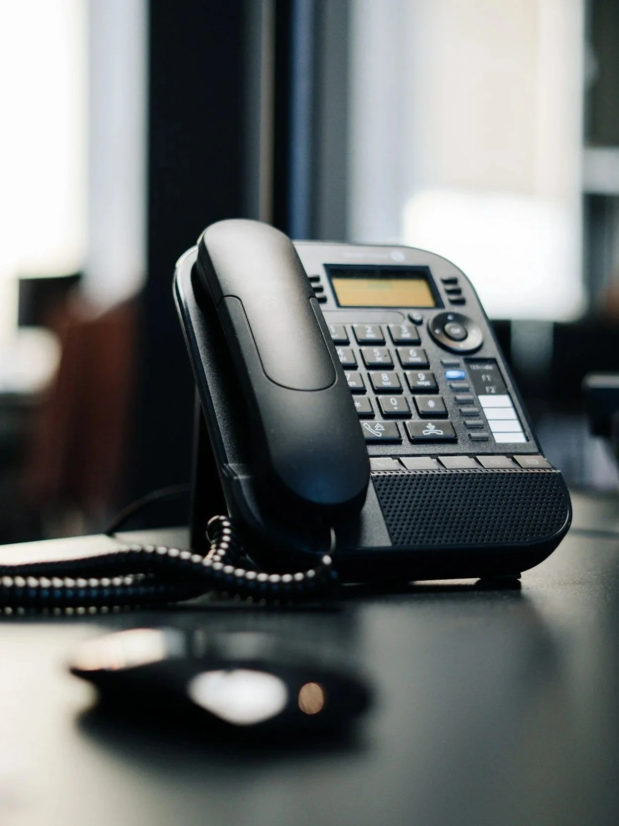 Desk phone on a flat surface with a blurred background.