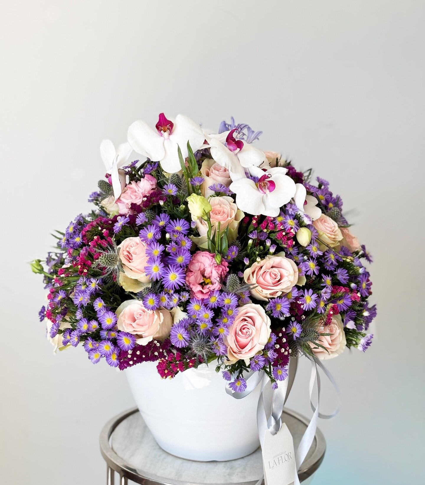 Un arreglo que celebra la delicadeza en cada p&eacute;talo: rosas blush, asters en tonos lavanda y orqu&iacute;deas blancas que elevan la composici&oacute;n con elegancia atemporal.

Un gesto que habla de amor, gratitud y belleza &mdash; perfecto par