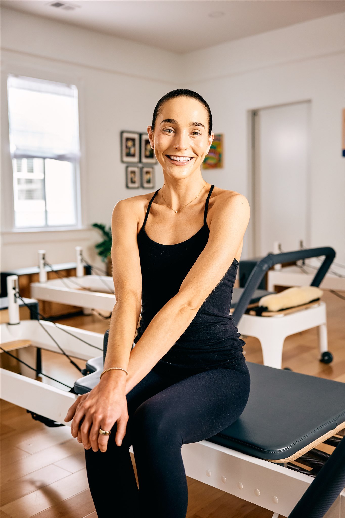 Woman with slicked back bun posing on a reformer