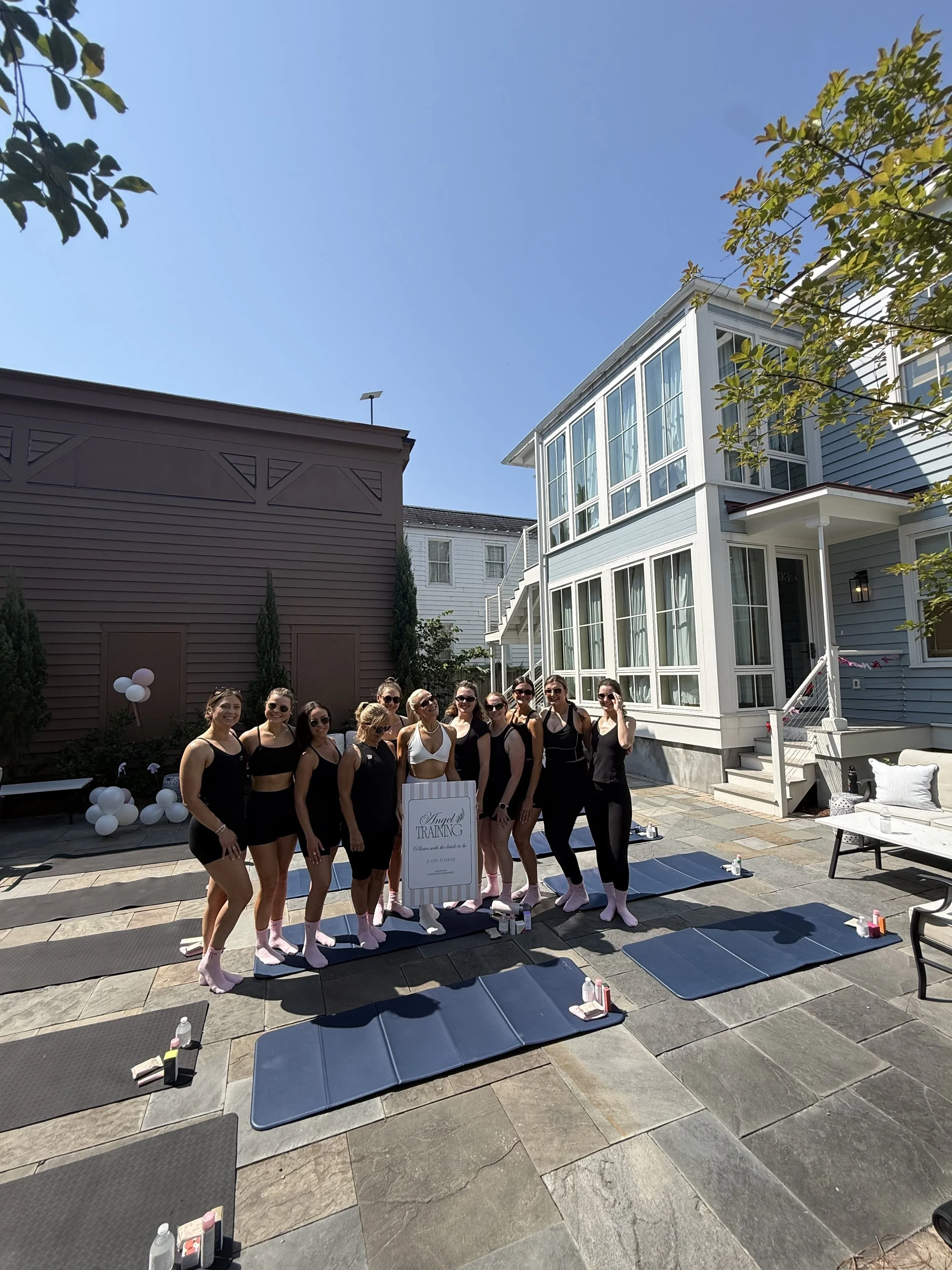 Group of women posing next to a charleston house around pilates mat on their bachelorette party
