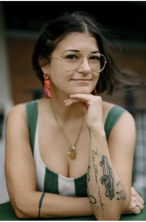 Image of a tan woman with short dark hair posing for a headshot