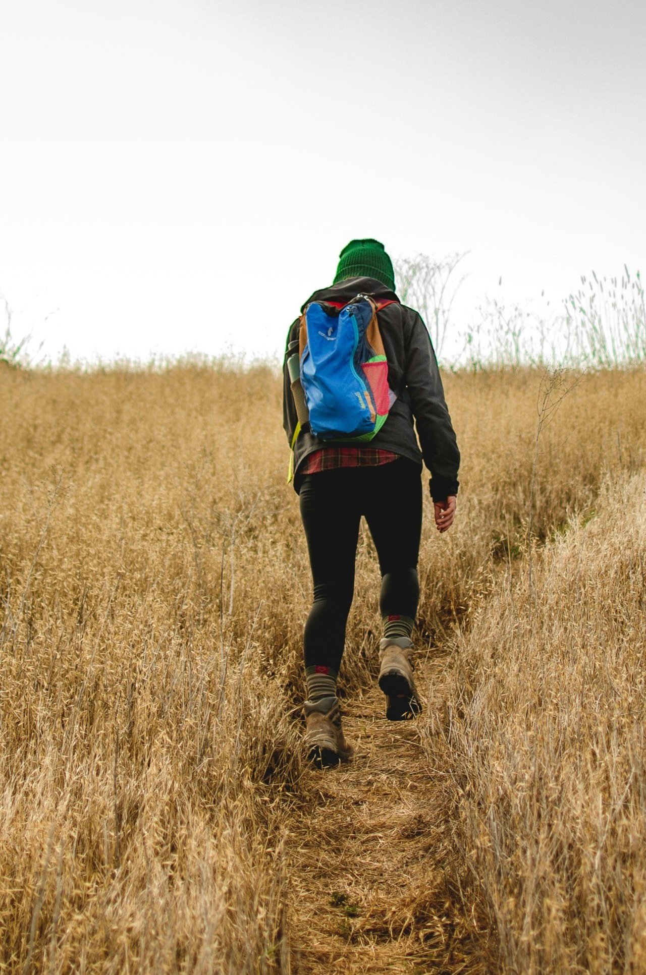 Person walking a trail with a backpack symbolizing the long-haul journey.
