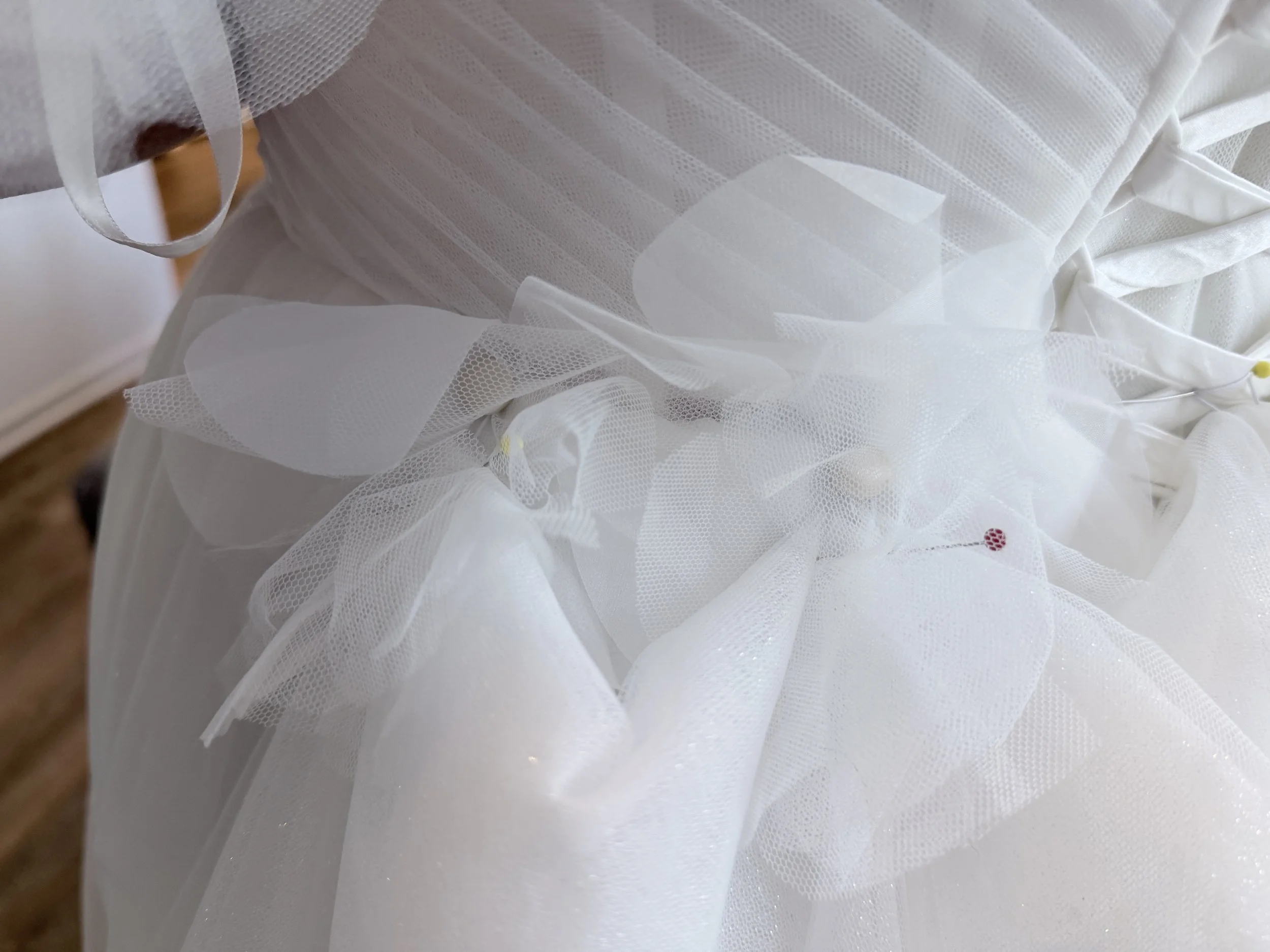 We added flowers at the waist with buttons for her bustle.
