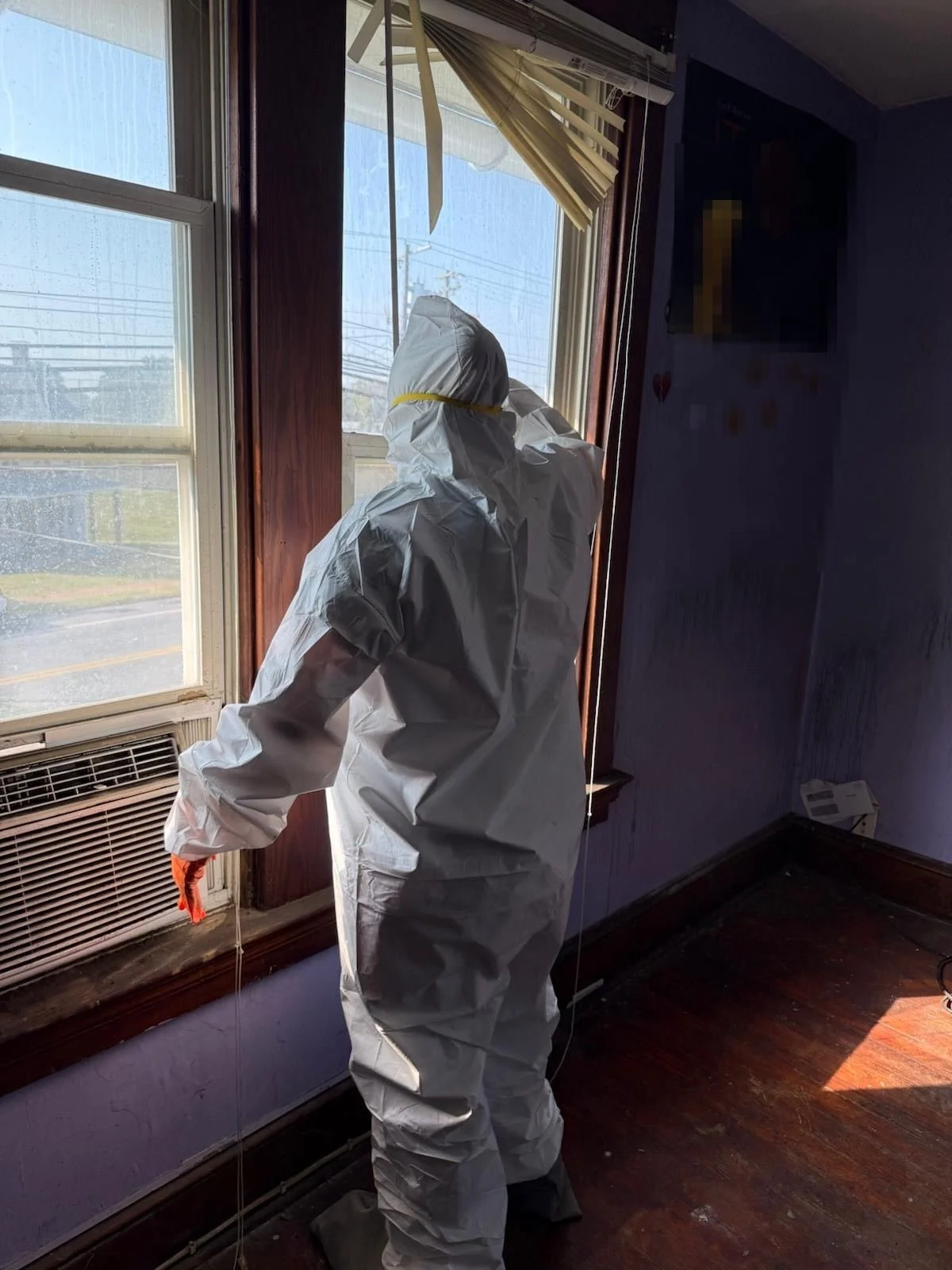 Crew member in protective suit during interior fire-damage remediation