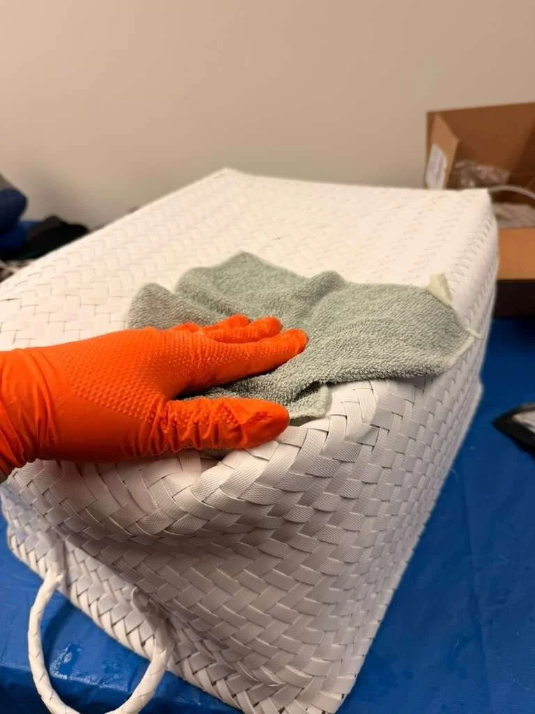 Gloved hand doing on-site contents cleaning of a woven basket