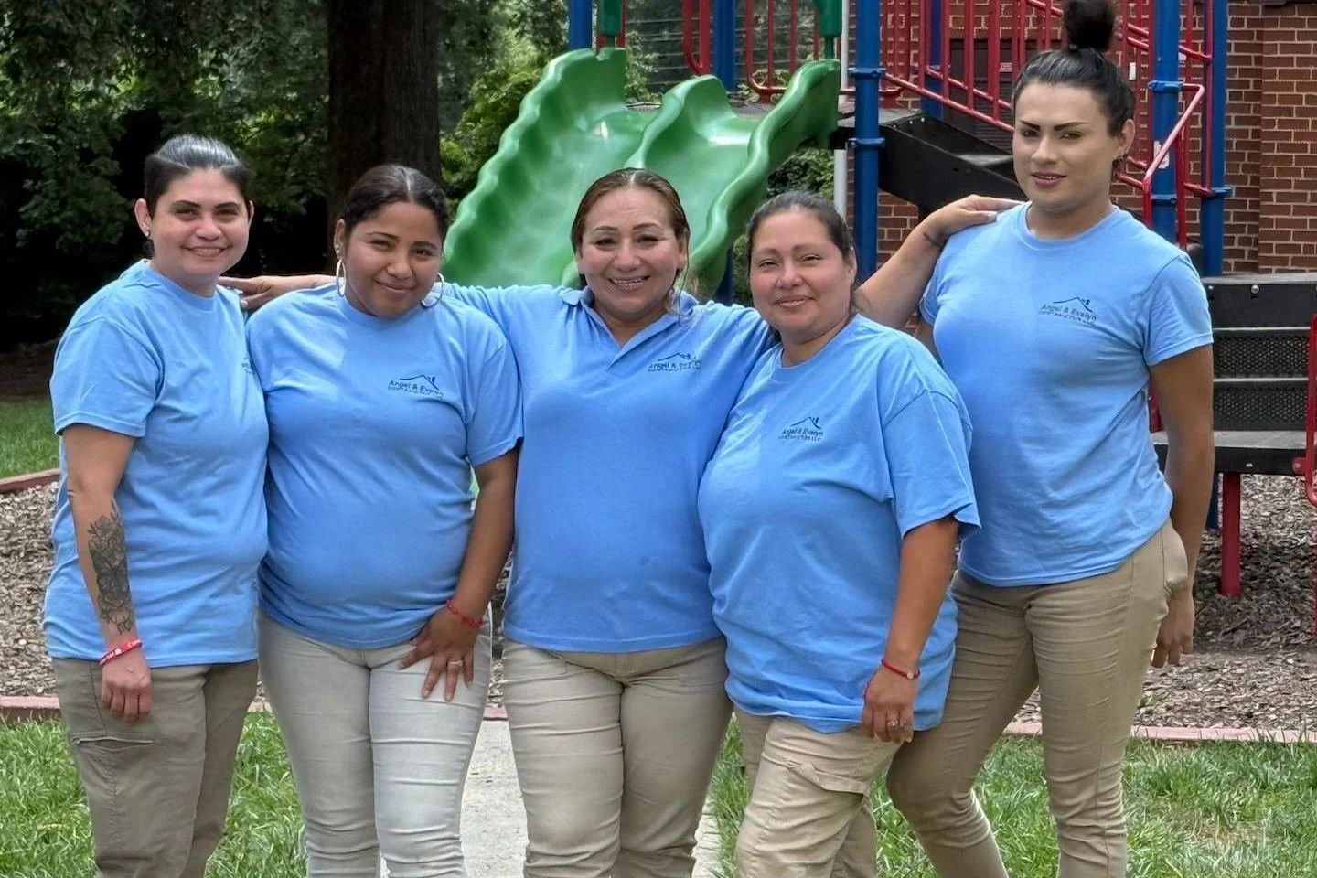 Crew members in company shirts posing together outdoors
