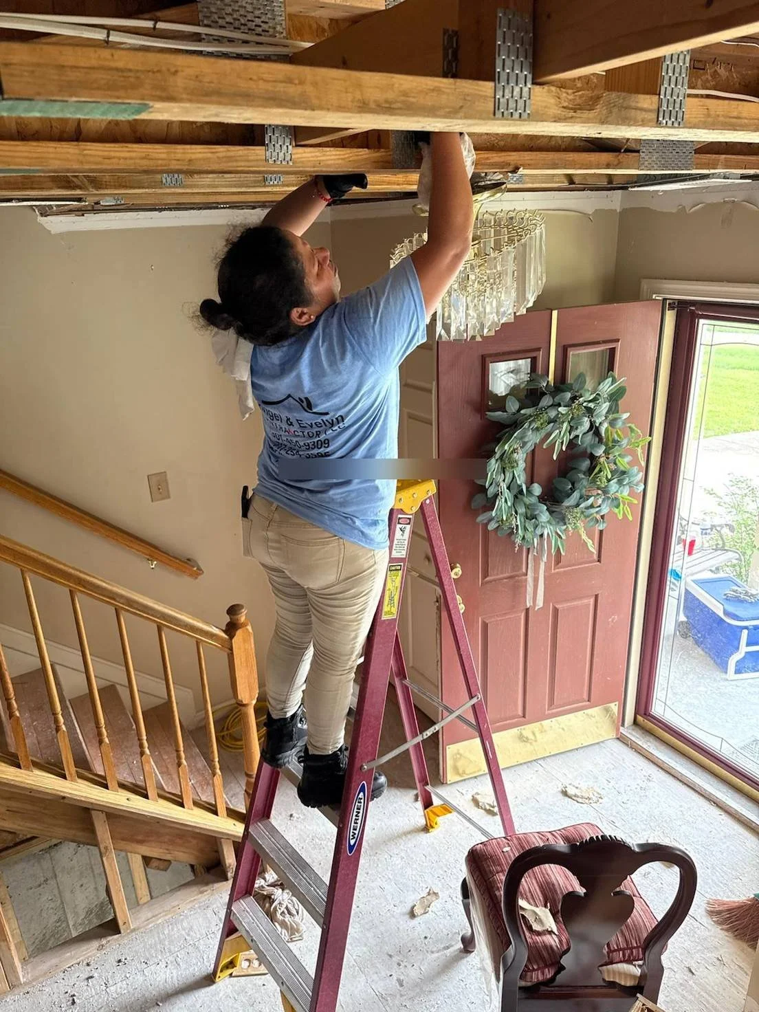 Crew member removing damaged ceiling during interior tear-out