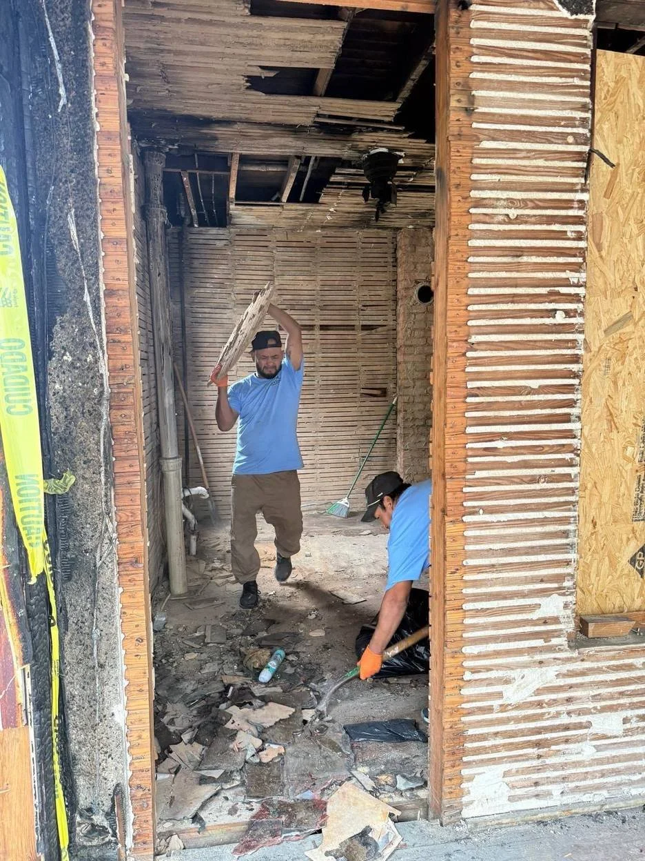 Crew members removing debris during interior fire-damage demolition
