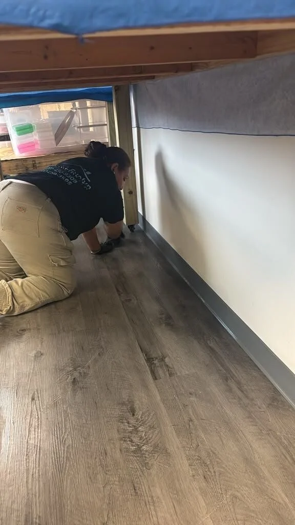 Crew member in a company shirt cleaning a floor