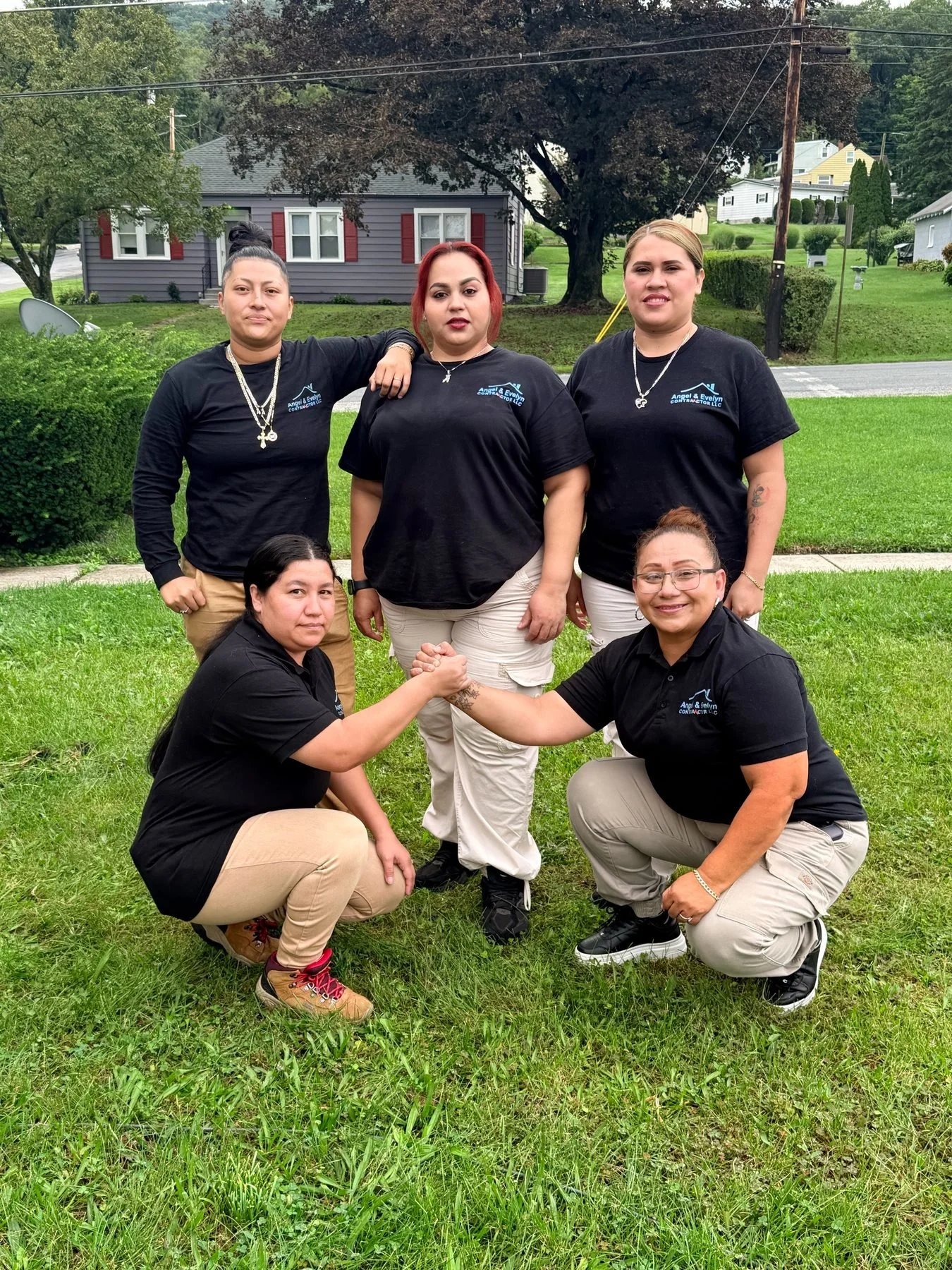 Angel & Evelyn crew members in company shirts posing on a lawn
