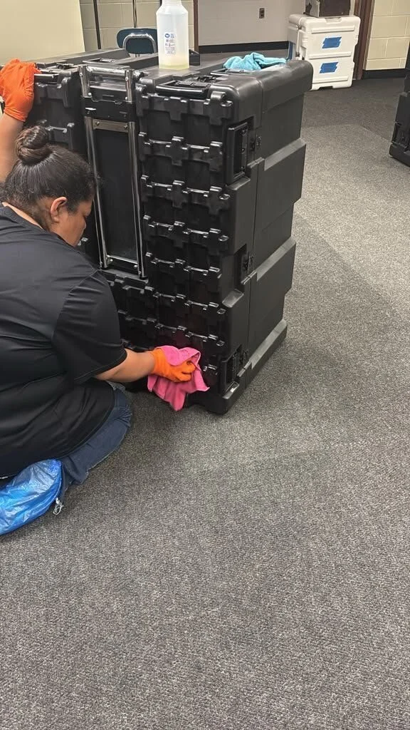 Crew member doing on-site contents cleaning of an equipment case