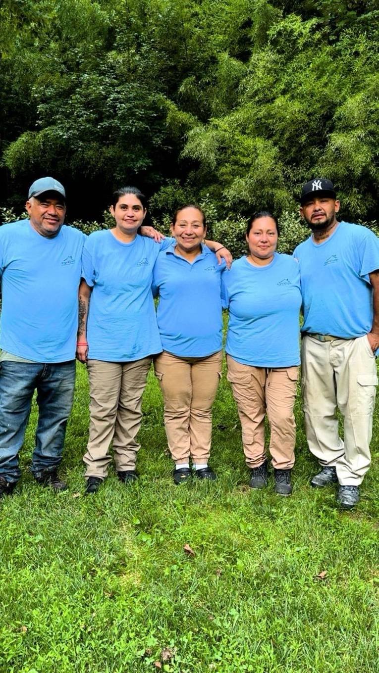 Crew members in company shirts posing together outdoors